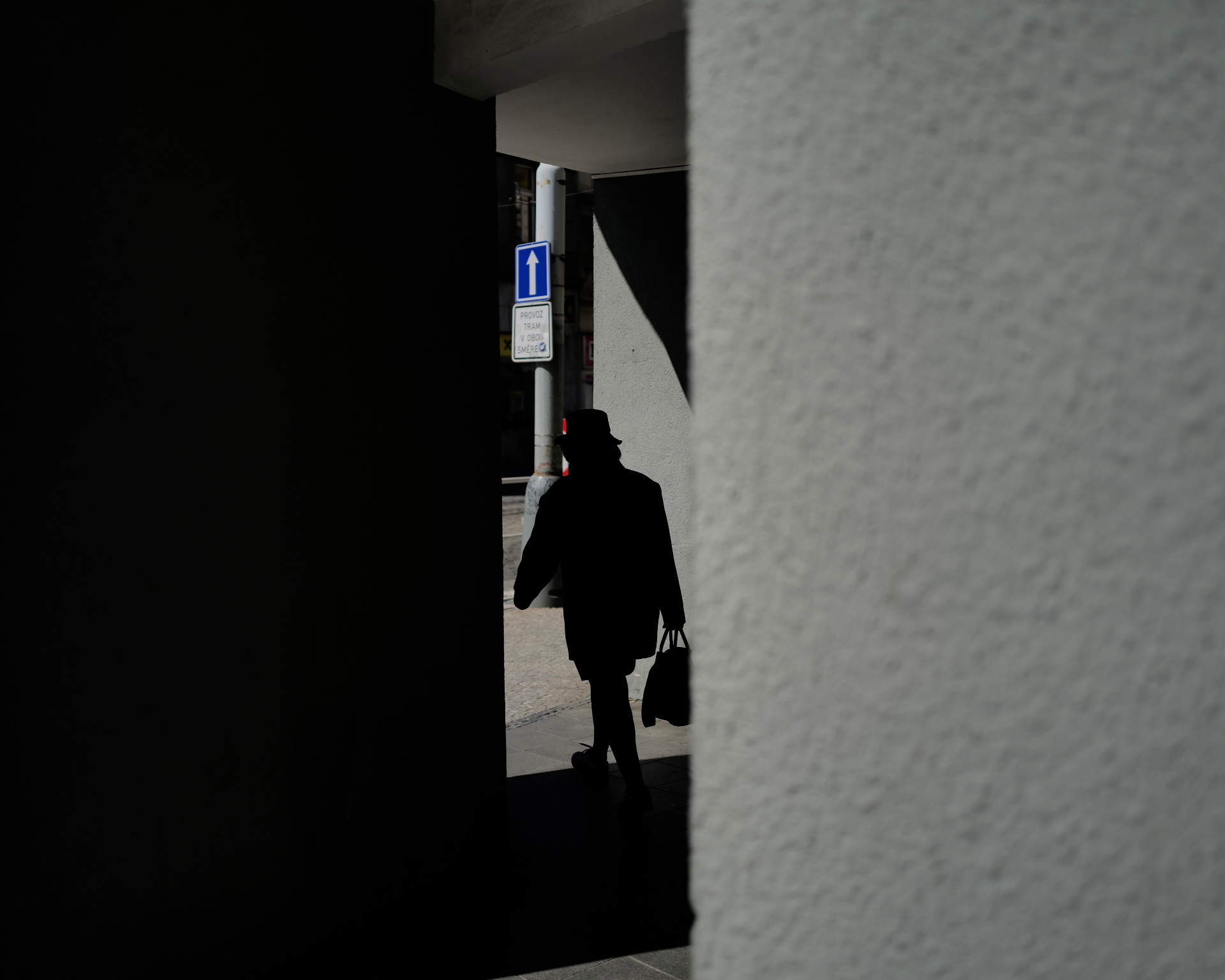 Silhouetted figure walking through a shaft of light